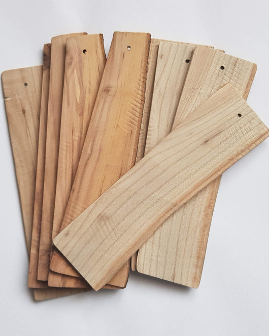 A stack of unfinished wooden bookmarks, ready to be painted or decorated.